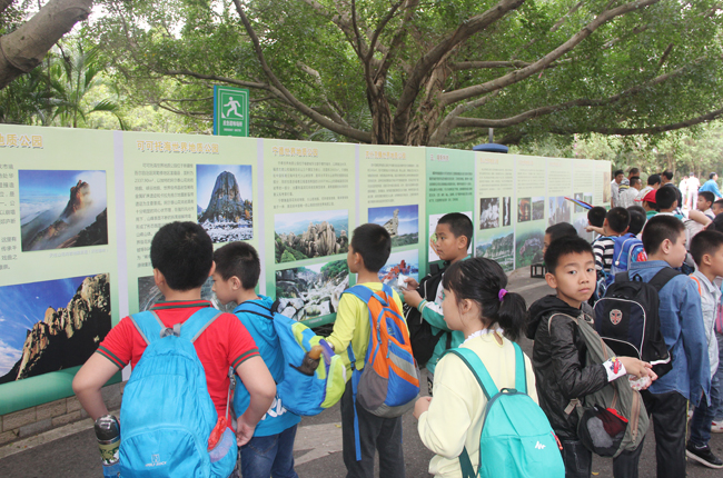 （3）参加活动的学生们饶有兴趣地在雷琼公园三岭山景区观看中国的世界地质公园图片展.jpg